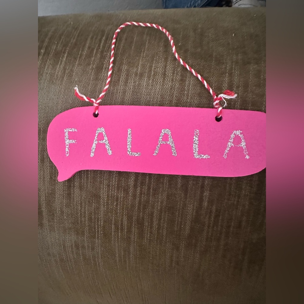 Pink wooden Christmas ornament sign with “Falala” on it